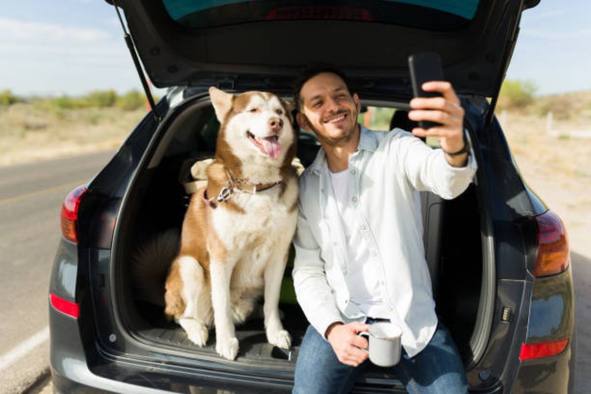 HonorHealth employee smiles in trunk of car with dog while using auto and pet insurance provided through HonorHealth employee benefits.