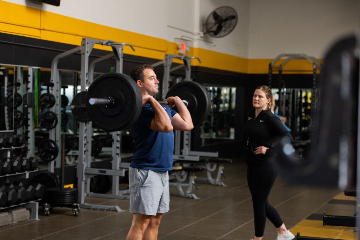 HonorHealth employee lifts weight in gym using One Pass employee benefit for gym discounts.