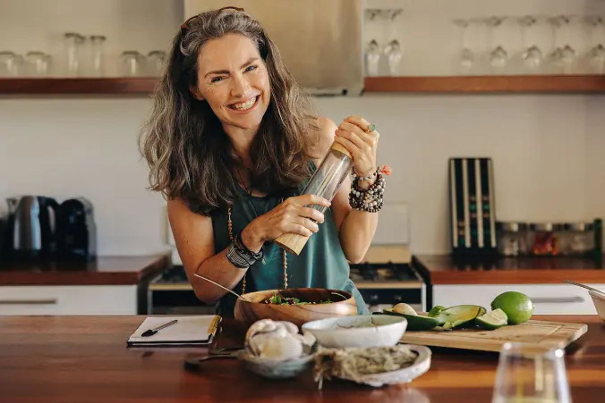 HonorHealth Integrative Medicine - Woman smiles while preparing healthy, nutritious meal.