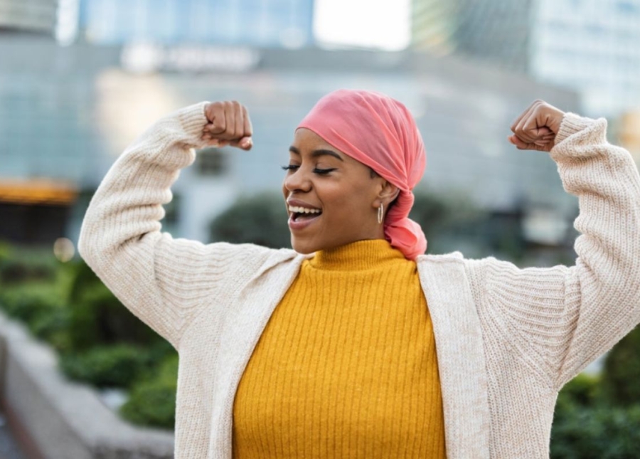HonorHealth patient flexes in strength and celebration after overcoming breast cancer with care from the Comprehensive Breast Center of Arizona in collaboration with HonorHealth.