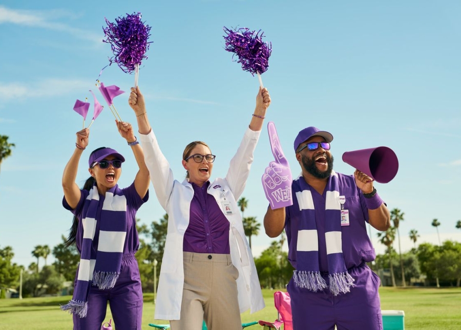 HonorHealth All of us. All for you. - Physicians stand on field holding cheerleading accessories while they cheer for patients.