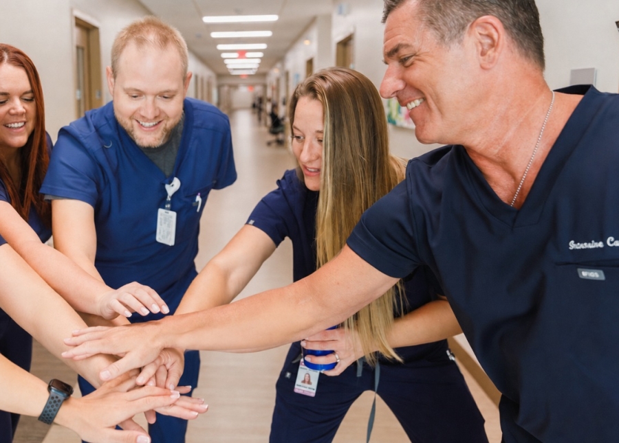 HonorHealth Nursing - Physicians and nurses gather in hallway of hospital for a motivational team cheer.