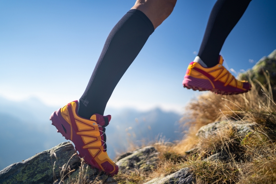HonorHealth Vein Program - Hiker runs up rocky hill in compression socks for optimal vein health.