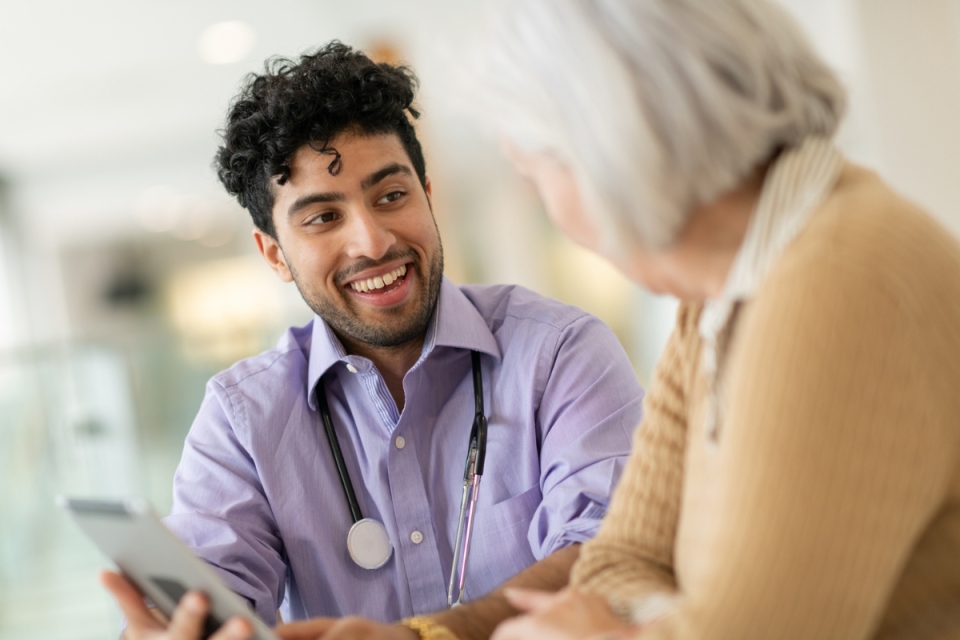 Why a resident doctor might be your smartest health choice - HonorHealth resident doctor smiles as he talks to elderly patient.