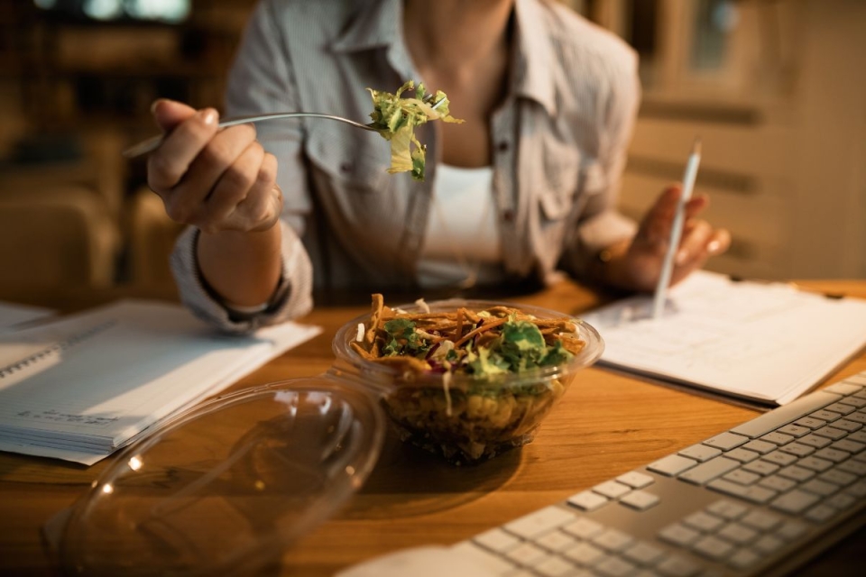 A woman holds up a fork about to unknowingly eat a salad that has more calories than a burger - HonorHealth Primary Care