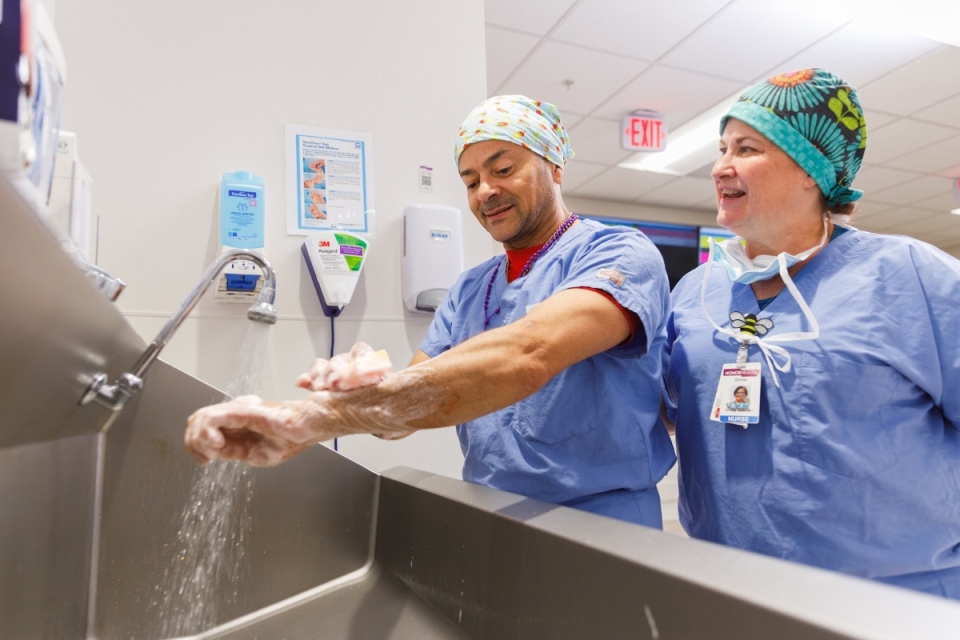 Two HonorHealth surgery providers wash and prepare their hands before entering the operating room to ensure safe, sterile care for patients.