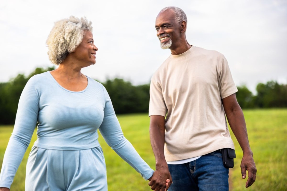 Older couple walking hand in hand outdoors after heart valve treatment, supported by HonorHealth Heart Care.