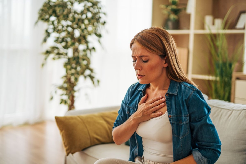 HonorHealth Heart Care - A woman experiences chest discomfort at home, a common yet often overlooked sign of heart attack in women.