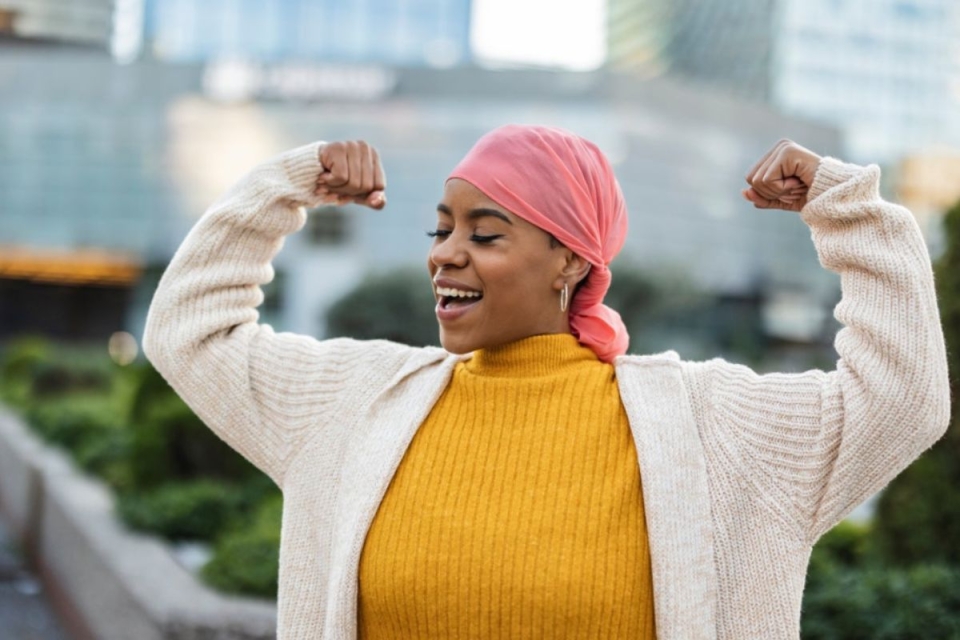 HonorHealth patient flexes in strength and celebration after overcoming breast cancer with care from the Comprehensive Breast Center of Arizona in collaboration with HonorHealth.