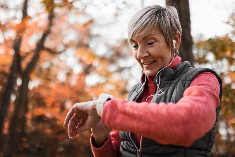 HonorHealth Heart Care - Woman monitors heart health with smart watch on jog outside.