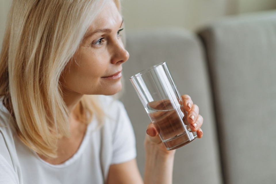Woman over 45 years old drinks water in preparation for colonoscopy at HonorHealth.