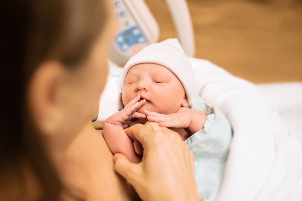 HonorHealth Maternity - Woman holds newly delivered baby in hospital.