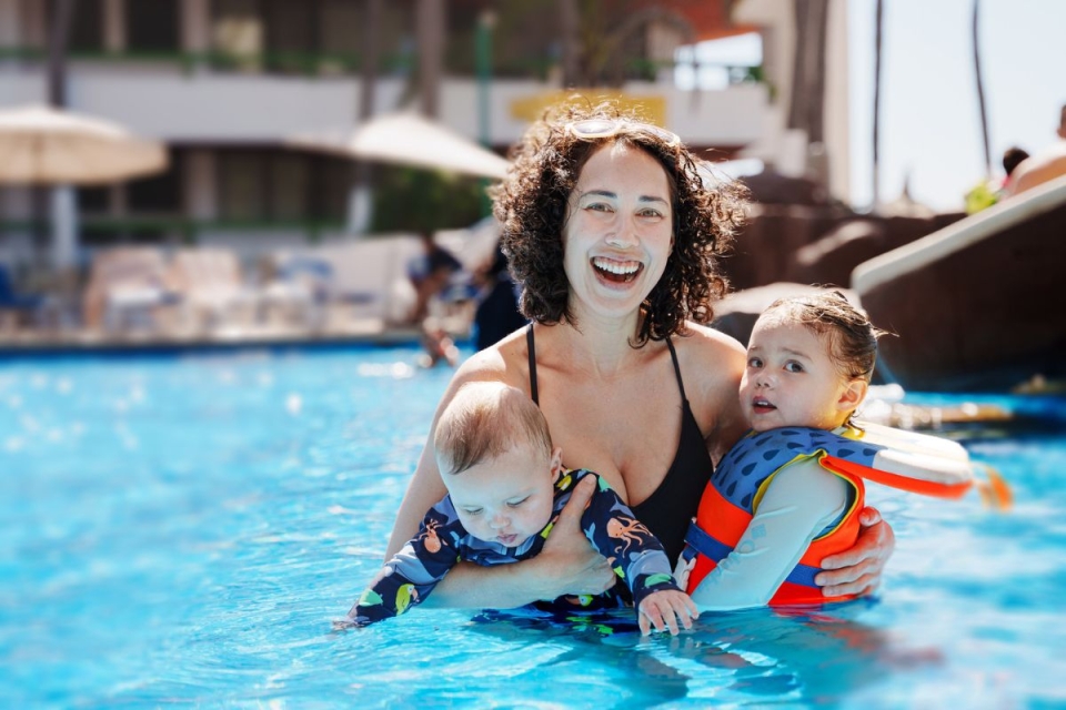 HonorHealth Primary Care - Mother and two young children safely enjoy hot Arizona summer in pool after using HonorHealth Arizona summer safety tips.