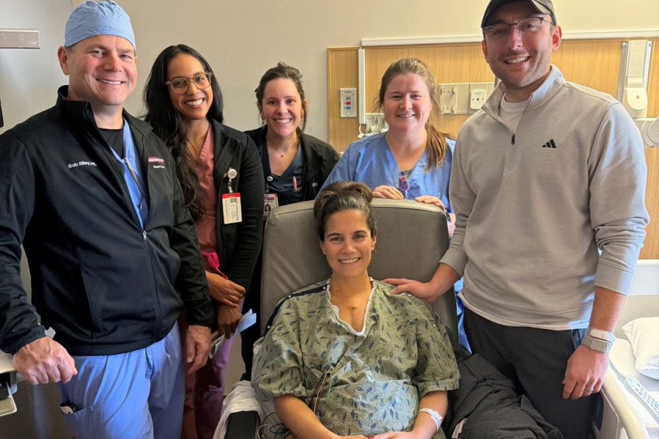 Pregnant patient, her partner and HonorHealth staff smile during a group photo after lifesaving treatment for a dangerous heart infection.