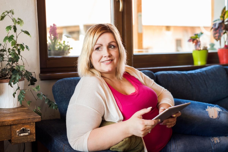HonorHealth General Surgery - Woman smiles on couch after having a minimally invasive robotic weight loss surgery.