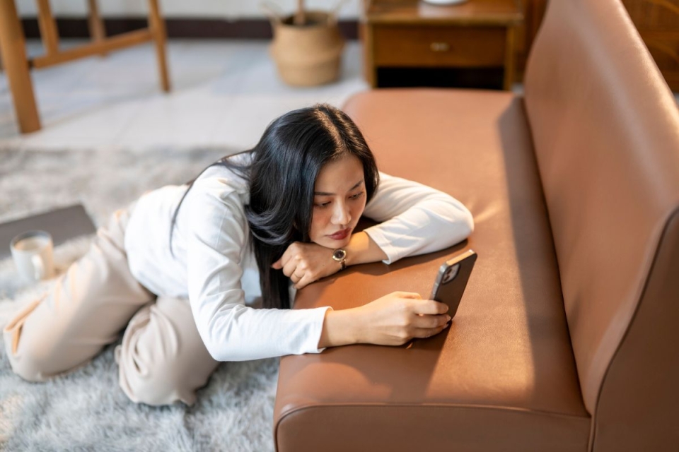 HonorHealth Neurology - Woman doomscrolls on phone, which experts say can contribute to declining mental health, poor sleep quality and difficulty focusing.