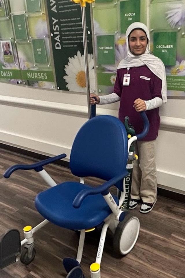 HonorHealth high school volunteer student operates medical chair equipment.