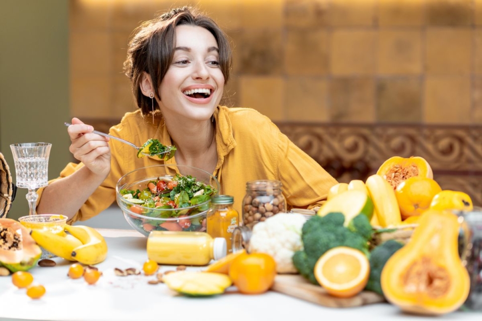 HonorHealth Whole Health Institute - Woman smiles while eating anti-inflammatory diet foods.