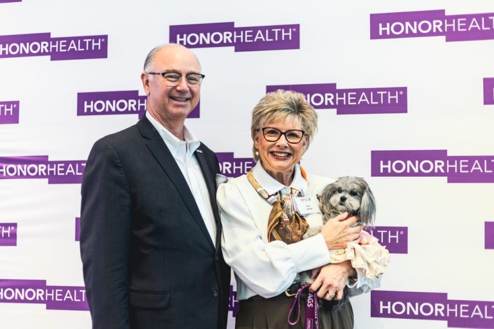 Mia, a local therapy dog, poses for photo at HonorHealth's WPLC event with HonorHealth CEO Todd LaPorte. 