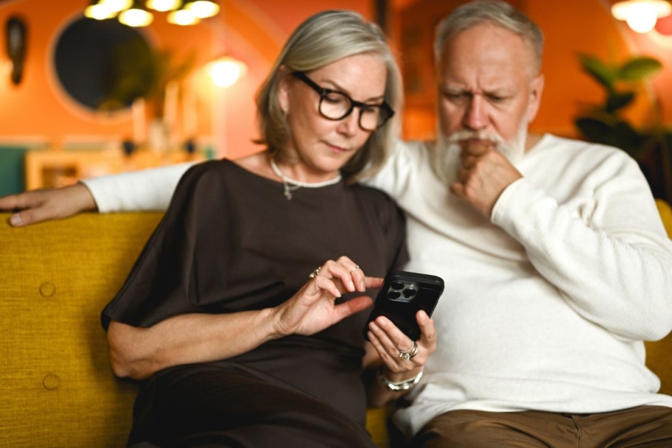 Couple looks at phone after receiving a fraudulent MyChart scam email.