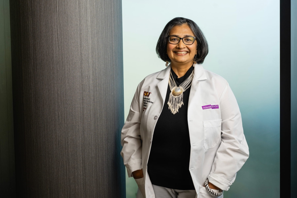 Priya Radhakrishnan, MD, HonorHealth chief academic officer, smiling in a white lab coat.