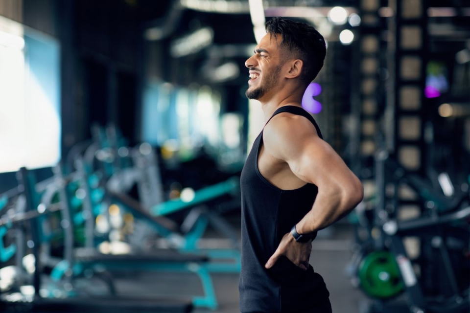 HonorHealth Pain Care - Man with chronic back pain winces during exercise.