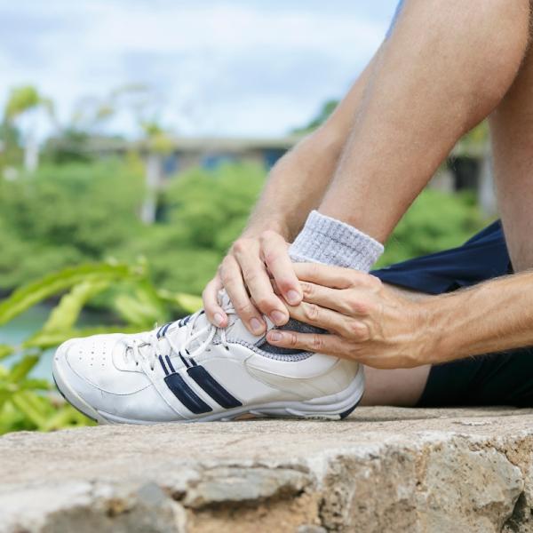 Person holding their ankle in pain from arthritis—relevant to care offered by HonorHealth Orthopedics.