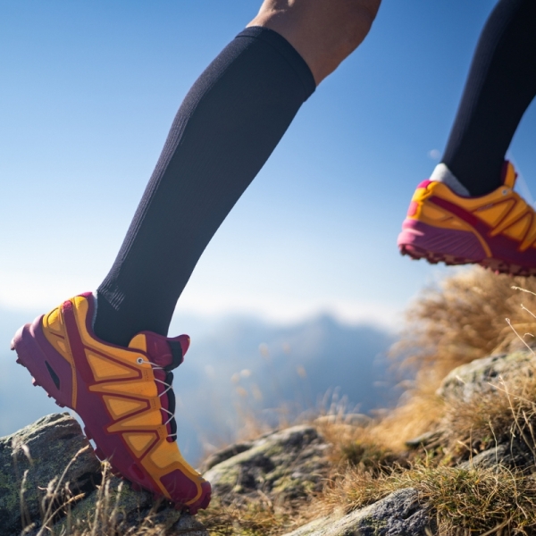 HonorHealth Vein Program - Hiker runs up rocky hill in compression socks for optimal vein health.