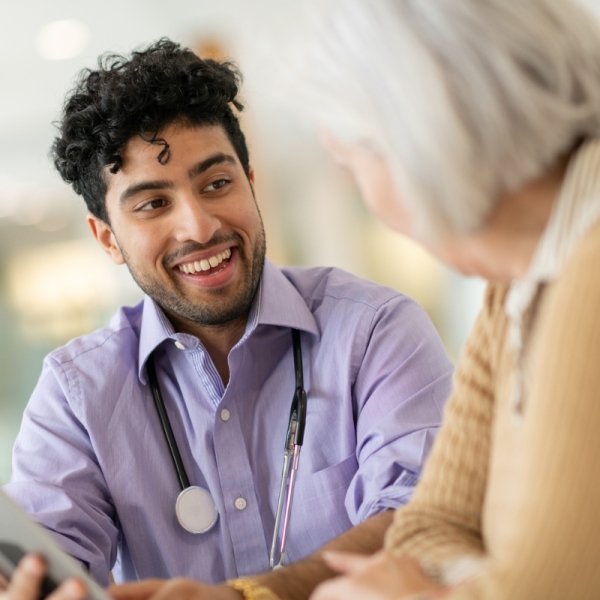 Why a resident doctor might be your smartest health choice - HonorHealth resident doctor smiles as he talks to elderly patient.