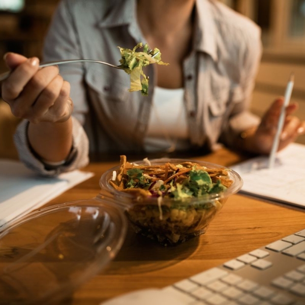 A woman holds up a fork about to unknowingly eat a salad that has more calories than a burger - HonorHealth Primary Care