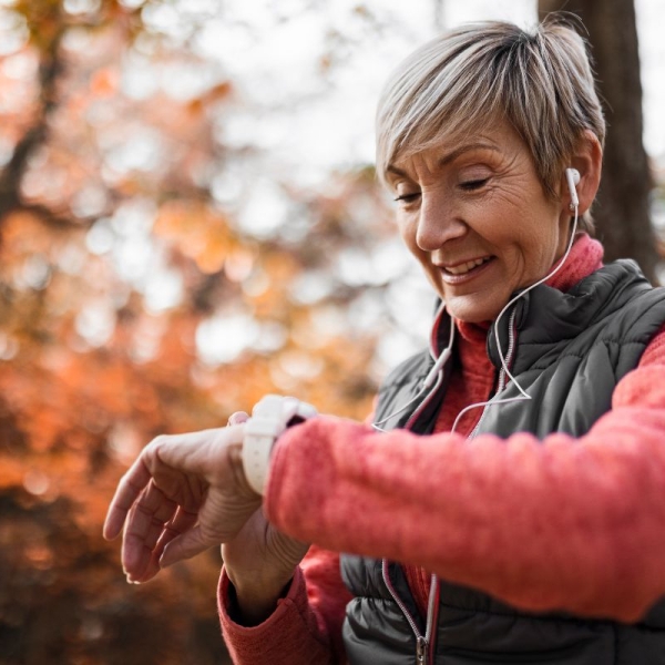 HonorHealth Heart Care - Woman monitors heart health with smart watch on jog outside.