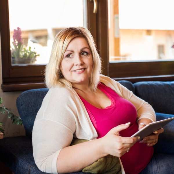 HonorHealth General Surgery - Woman smiles on couch after having a minimally invasive robotic weight loss surgery.