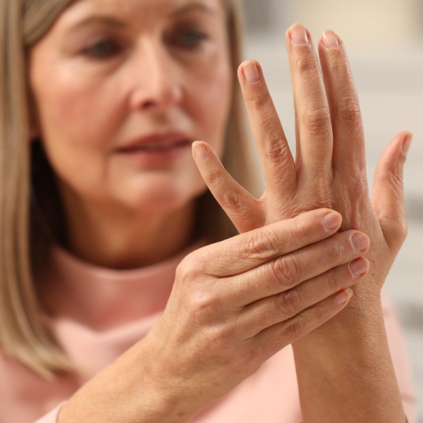 HonorHealth General Surgery - Woman holds aching hand with arthritis, considering GLP-1 weight loss drug for relief.