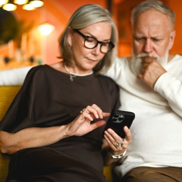 Couple looks at phone after receiving a fraudulent MyChart scam email.