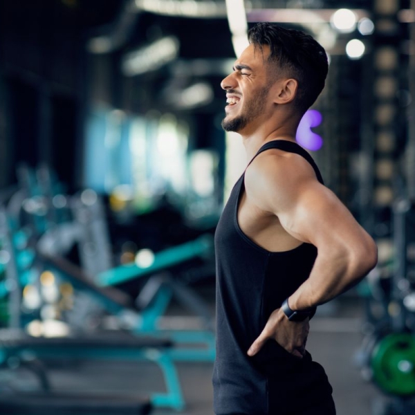 HonorHealth Pain Care - Man with chronic back pain winces during exercise.