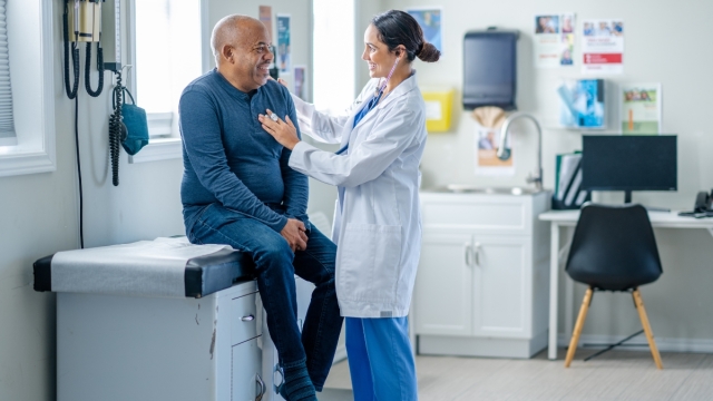 HonorHealth Primary Care Physician performs check up with stethoscope on male patient.