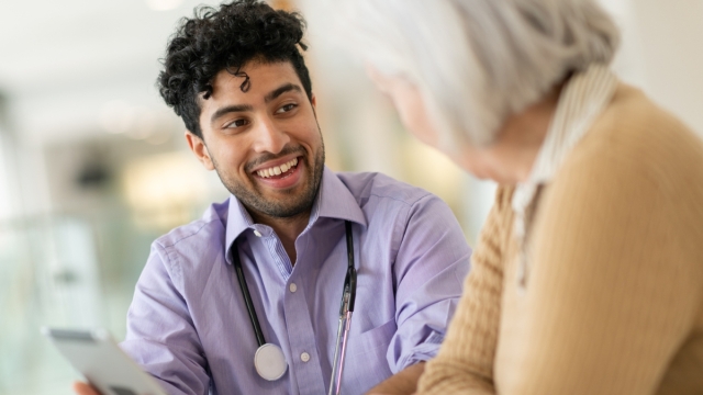 Why a resident doctor might be your smartest health choice - HonorHealth resident doctor smiles as he talks to elderly patient.