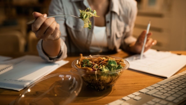 A woman holds up a fork about to unknowingly eat a salad that has more calories than a burger - HonorHealth Primary Care