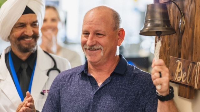HonorHealth Care Care - HonorHealth staff applaud male patient as he rings a bell celebrating that he is now cancer-free.