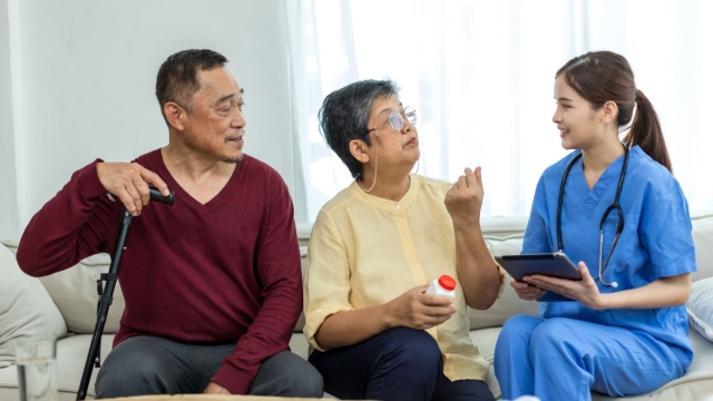 HonorHealth Neuroscience - Doctor sits with male neurology patient with cane and his wife to discuss treatment options.