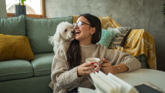 HonorHealth Whole Health Institute - Woman smiles while sitting on the ground with dog during a digital detox to reduce stress.