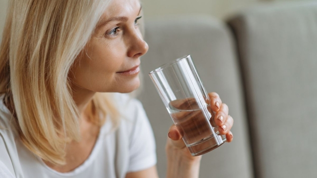 Woman over 45 years old drinks water in preparation for colonoscopy at HonorHealth.