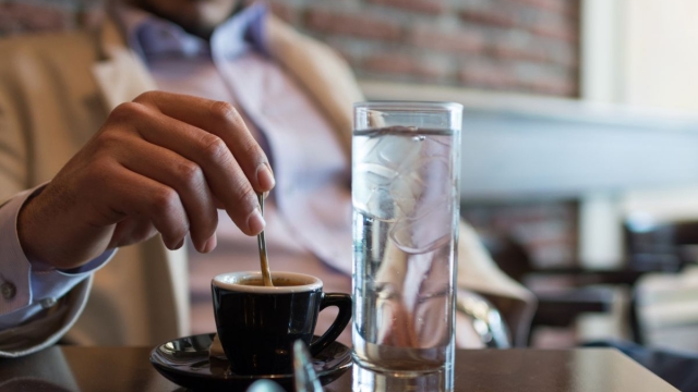 Man drinks glass of water before coffee in the morning, as directed by HonorHealth gastroenterologist.