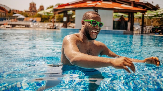 Get summer-body ready with HonorHealth Primary Care - Man smiles while swimming in pool during summer.