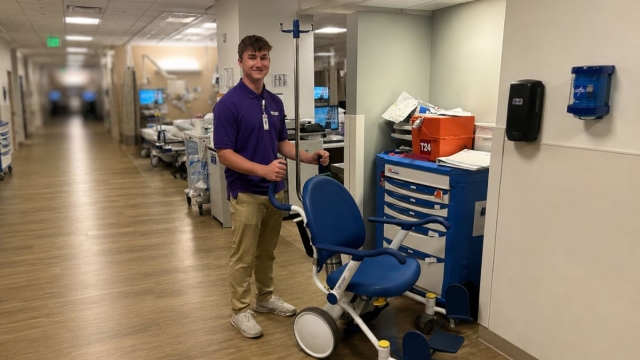 HonorHealth College Volunteer Program student volunteer, Jacob, manages medical equipment chair.
