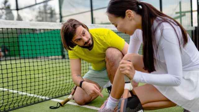 HonorHealth non-operative sports medicine - Coach sits with woman on court after a pickleball injury.
