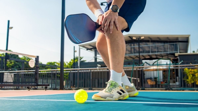 HonorHealth Sports Medicine - Man grips painful knee on court due to pickleball injury.