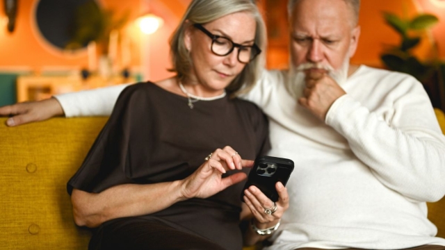 Couple looks at phone after receiving a fraudulent MyChart scam email.