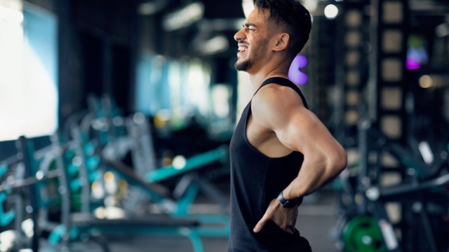 HonorHealth Pain Care - Man with chronic back pain winces during exercise.